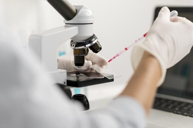 doctor testing cells under a microscope